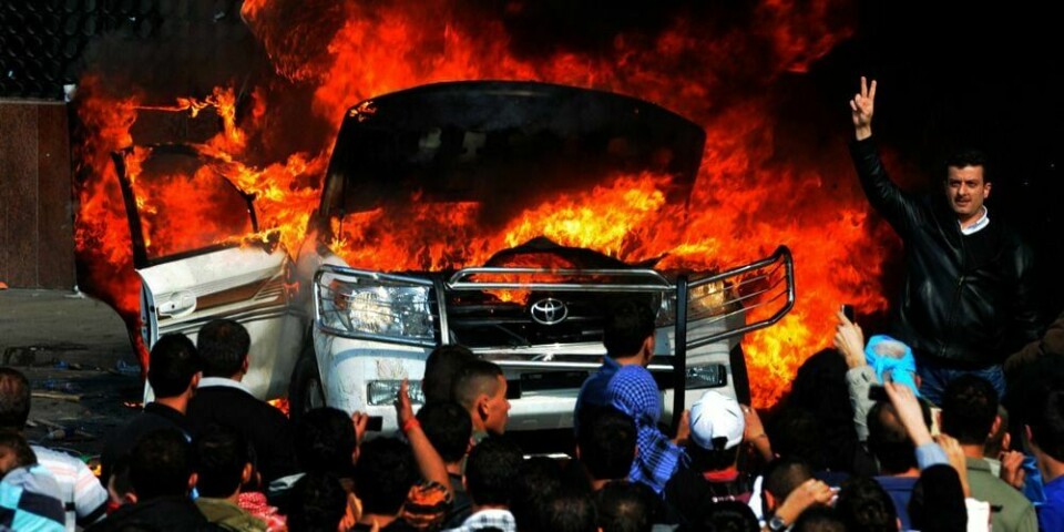 SINTE: Demonstanter i den libanesiske byen Tripoli tente fyr på bilen til TV-kanalen Al Jazeera. Kanalen er Hizbollah-vennlig, mente de. Demonstrantene vil ikke at den sjia-muslimske gruppa Hizbollah bestemmer politikken.