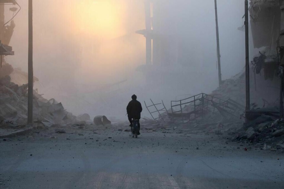 RUINER: Enda en bygning er bombet i Øst-Aleppo. Støvet fra bombingene brer seg i byen. Igjen ligger mange døde mennesker.