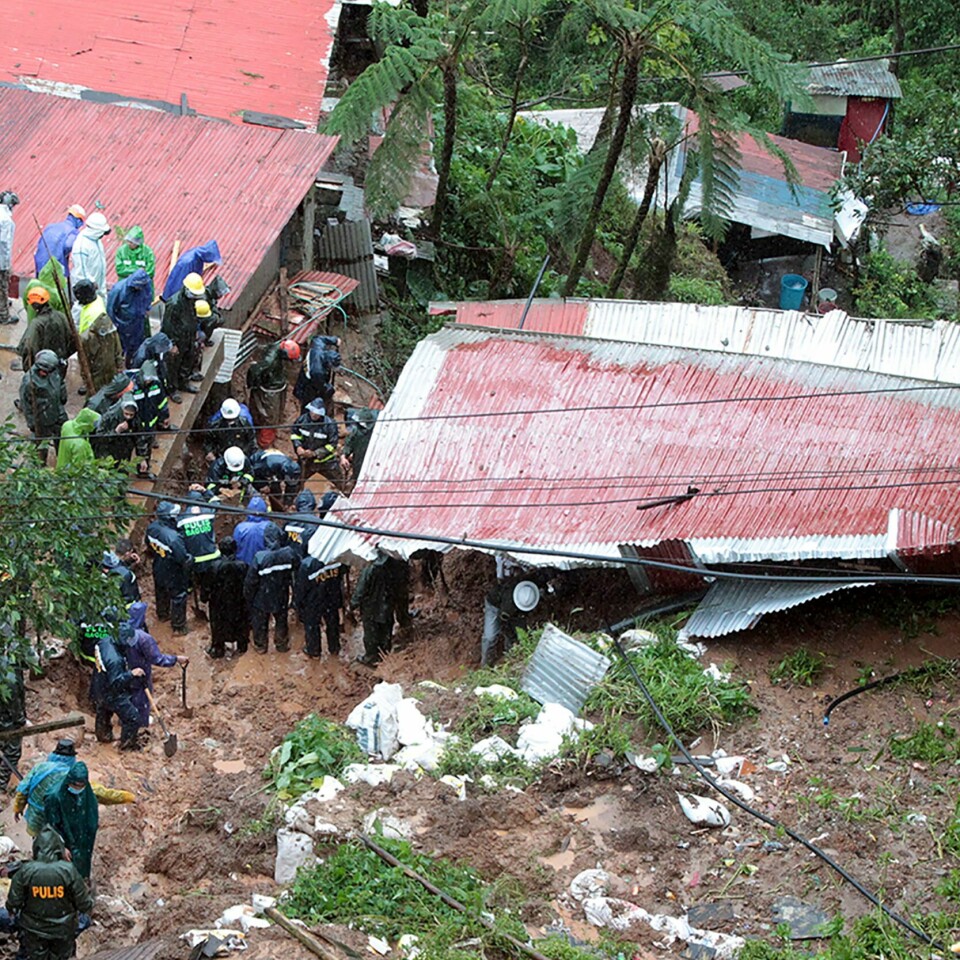LETER: Myndighetene leter fortsatt etter overlevne etter uværet i Filippinene. Redningsmannskap leter etter ofre i et hus som ble tatt av jordskred i Baguio tirsdag. Foto: AP / NTB