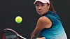 Bildet er av tennisspilleren Peng Shuai. Hun ser på en ball mens hun gjør seg klar for å slå den med en tennisracket.