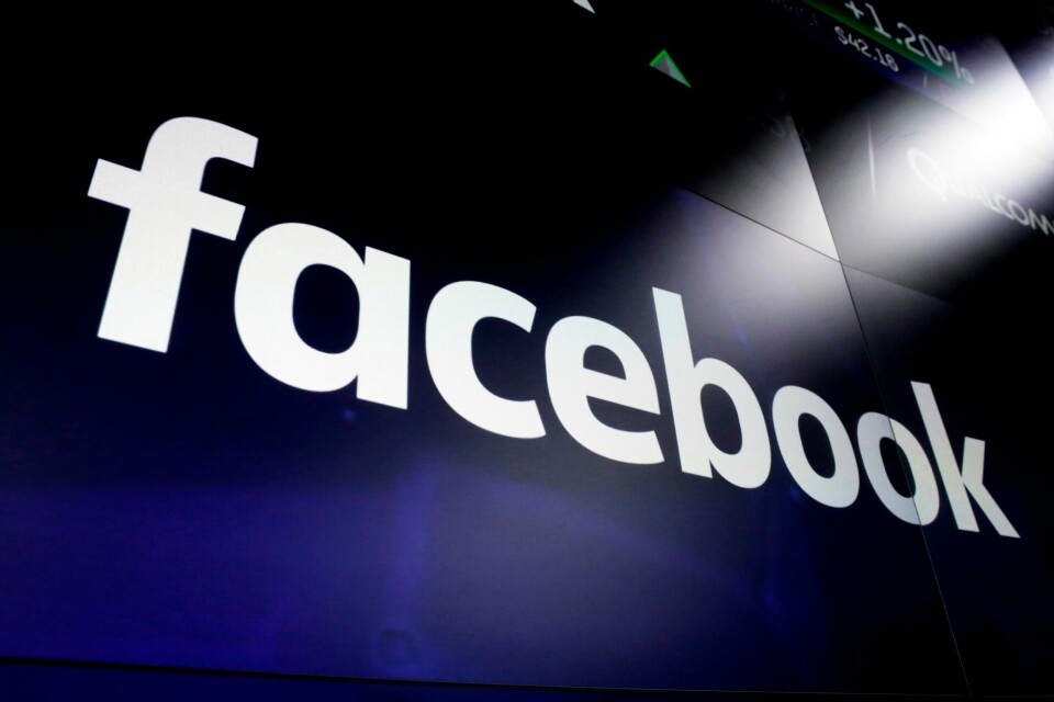 FEIL: Facebook sliter med å bruke sine egne regler og krav for politiske annonser. Bildet er av en vegg med store skjermer. Facebook sin logo dekker mange av skjermene. Den er hvit mot blå bakgrunn. Arkivfoto: Richard Drew / AP / NTB