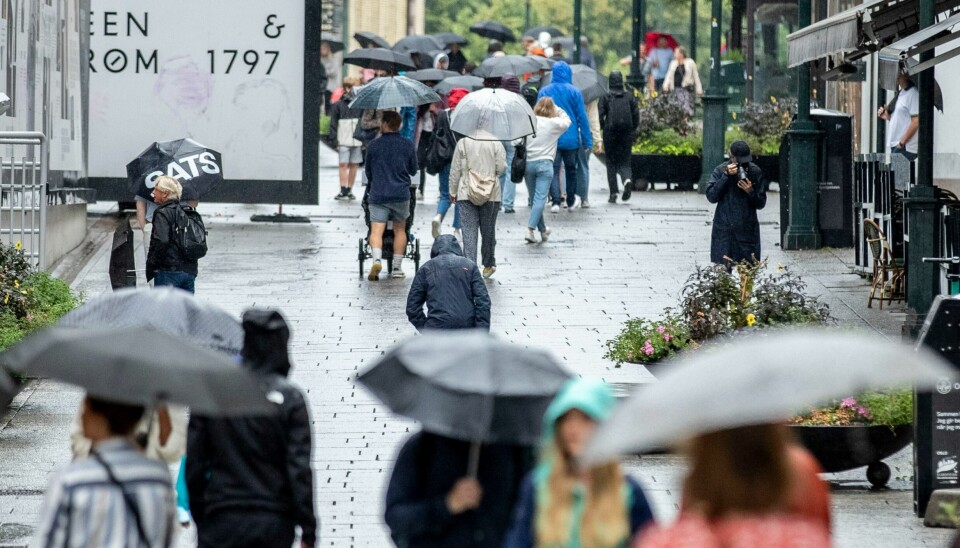 REGN: 1. mai byr på regn flere steder i landet. (Foto: Beate Oma Dahle/NPK) Bilde av folk som går med paraply i regnet. Foto: Beate Oma Dahle/NPK