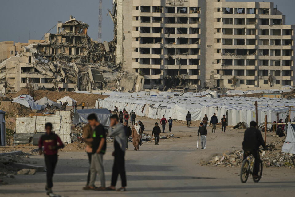 GAZASTRIPEN: Over 300 barn er drept på Gazastripen de siste ti dagene. Unicef ber om at angrepene stopper. Palestinere går ved siden av en teltleir for fordrevne vest på Gazastripen. Foto: Jehad Alshrafi / AP / NTB