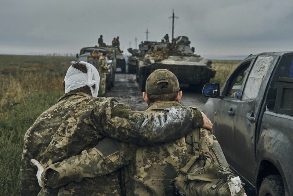 UKRAINA: Trumps utspill sjokkerer ukrainere. Arkivbildet fra 12. september 2022 viser en ukrainsk soldat som hjelper en annen ukrainsk soldat som er såret i russiske angrep Kharkiv-regionen. Foto: Kostjantyn Liberov / AP / NTB