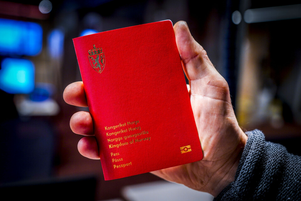 PASS: I år går 395 000 pass ut på dato. Bildet viser en hånd som holder et pass. Foto: Lise Åserud / NTB