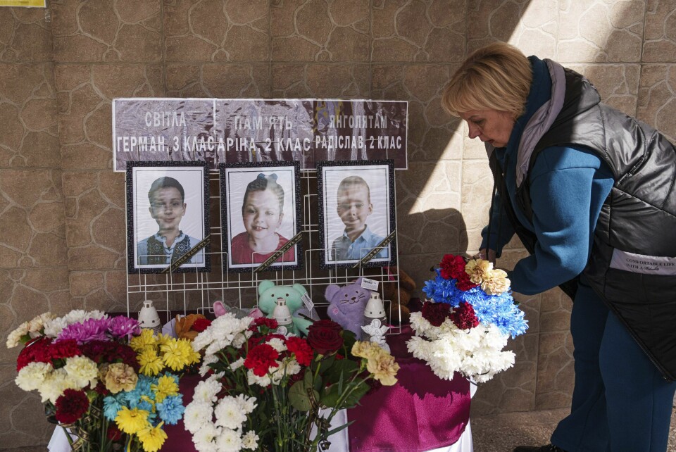 KRIG: En ukrainsk kvinne legger ned blomster foran bilder av tre av de ni barna som ble drept forrige uke. Russland skjøt raketter mot byen Kryvyj Rih. En ukrainsk kvinne legger ned blomster foran bilder av tre av de ni barna som ble drept i et russisk luftangrep mot byen Kryvyj Rih forrige uke. Foto: Jevhen Maloletka / AP / NTB