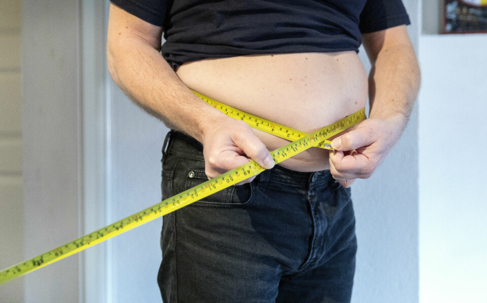 OVERVEKT: Mange folk med overvekt og fedme føler at andre ser ned på dem, ifølge ny undersøkelse. Bildet viser en mann som måler midjen sin med målebånd. Foto: NTB / NTB / NPK