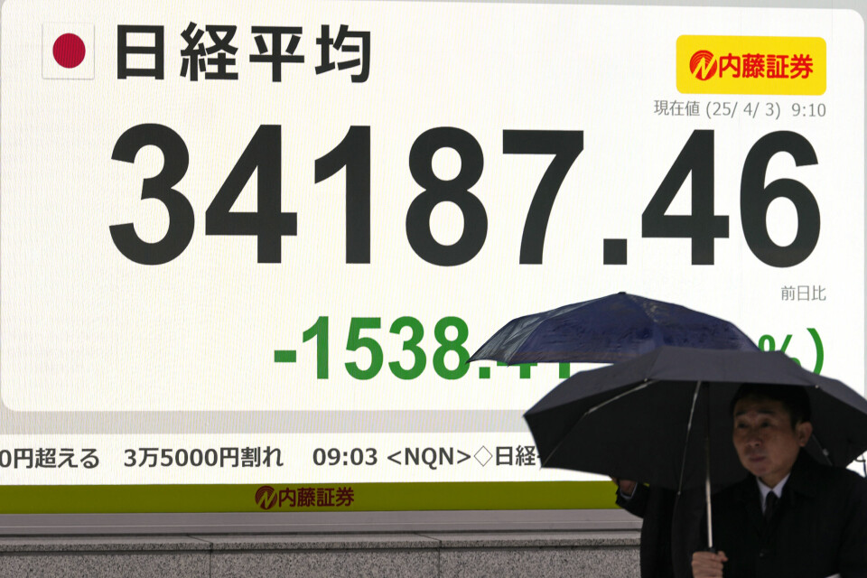 KRAFTIG NED: Børsene åpnet med nedgang i Asia mandag. Bildet viser at børsene åpnet med skarp nedgang i Asia mandag. Det ventes ytterligere nedgang også på Wall Street. Foto: Shuji Kajiyama / AP / NTB