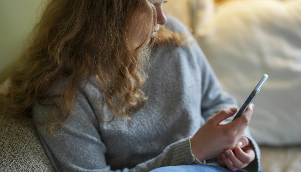 TILLIT: Unge kvinner har mer tillit til norske medier enn unge menn. Bilde av jente med mobiltelefon i hånden. Foto: Lise Åserud / NTB