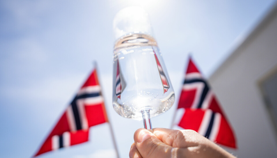 ALKOHOL: Halvparten av nordmenn mener at det er for mye alkohol på 17. mai. Bilde av flagg og champagneglass. Foto: Beate Oma Dahle / NTB