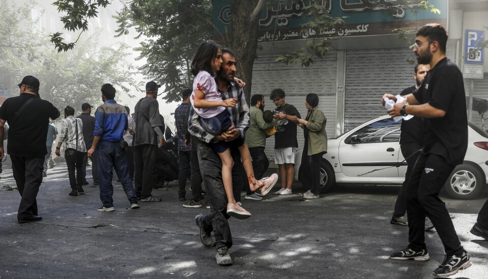 SKADDE: Israel gikk til angrep på Iran fredag. Siden har landene angrepet hverandre. Folk i Iran flykter. Bildet viser folk som løper etter angrep på Iran. Foto: AP Photo/Morteza Zangene/ISNA