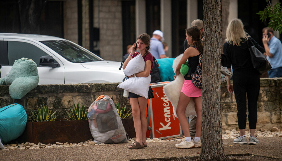 NATURKATASTROFE: En jente gråter mens hun snakker i telefonen. Hun har kommet seg til et sted hvor familier bli gjenforent etter flommen. Jente gråter med en pute i armene etter flommen i Texas.