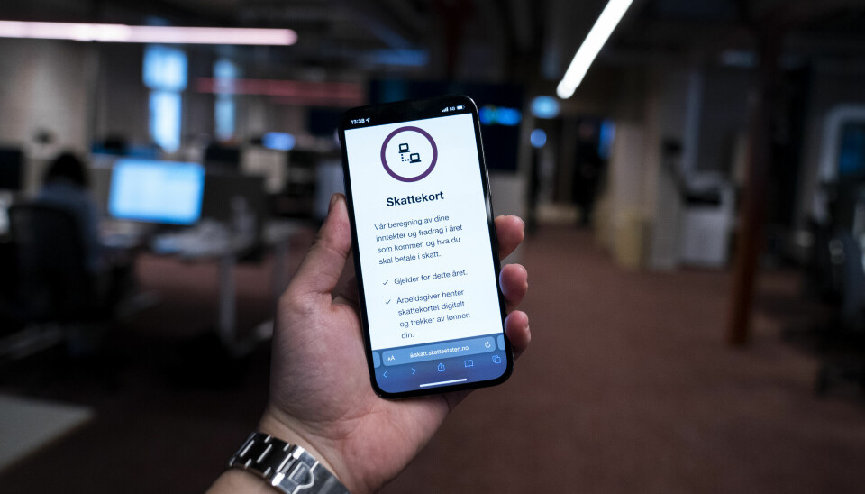 SKATT: Har du sjekket skattekortet ditt i år? Bildet viser en hånd som holder en telefon. På telefonen er nettsiden til Statteetaten med skattekort.