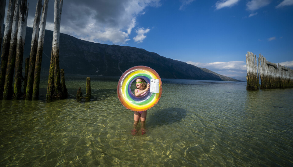 TURISTSESONG: Turistene som kommer til Lofoten om sommeren må ofte forvente litt rufsete vær. Det slipper de nå. Bildet viser en liten jente med flytering som bader i sjøen i Nord-Norge.