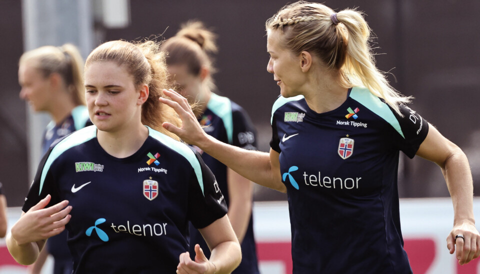 FOTBALL: Ada Hegerberg og Signe Gaupset under trening i Sveits før kvartfinalen mot Italia. To norske fotballspillere trener sammen. Den ene smiler og strekker hånden mot den andre.