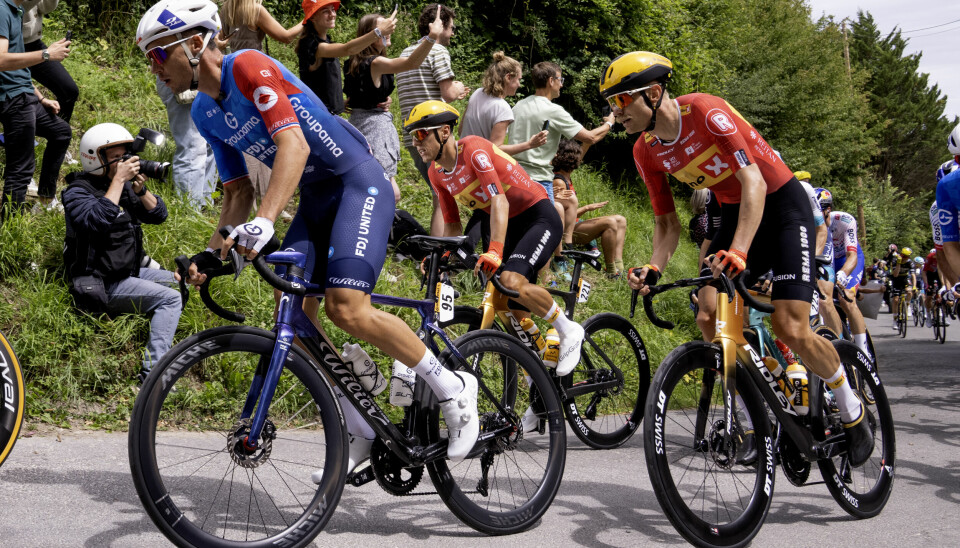 SYKKEL: Tobias Halland Johannessen (til venstre) imponerte under årets Tour de France. Her sammen med lagkamerat Magnus Cort (til høyre). Syklister sykler opp en bakke under årets Tour de France. På gresset står publikum og heier fram syklistene.