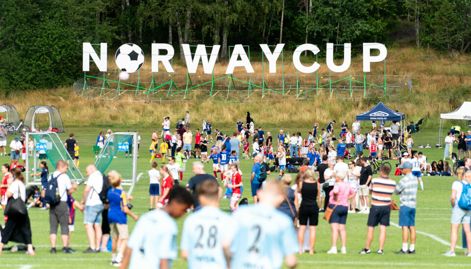MEGACUP: Nesten 30 000 personer mellom 6-19 år er meldt på Norway Cup. Bildet viser en fotballbane med masse barn og 'NORWAY CUP' skrevet på en banner bak banen.