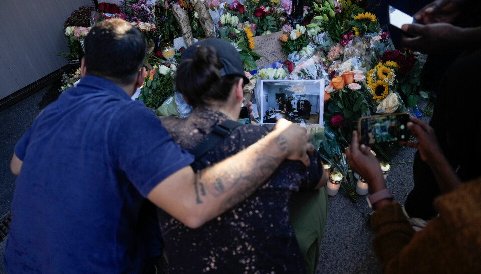 SØRGER: Mange har lagt ned blomster på Kampen. Bildet viser folk som sørger ved stedet der en kvinne ble drept på jobb natt til søndag i Oslo. Foto:
Javad Parsa / NTB