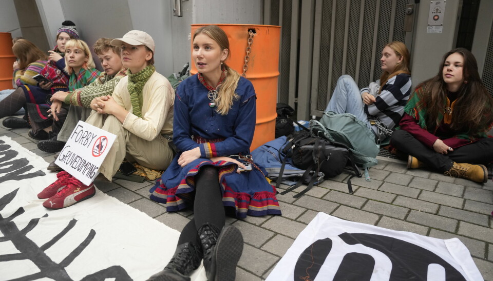AKSJON: Flere aktivister blokkerer inngangen til nærings- og fiskeridepartementet. Blant dem er artist Ella Marie Hætta Isaksen (midten).